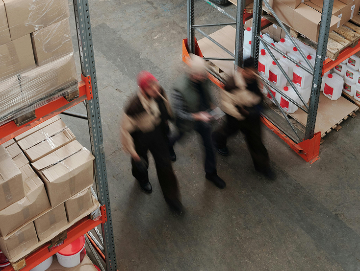 Warehouse workers moving goods between shelves
